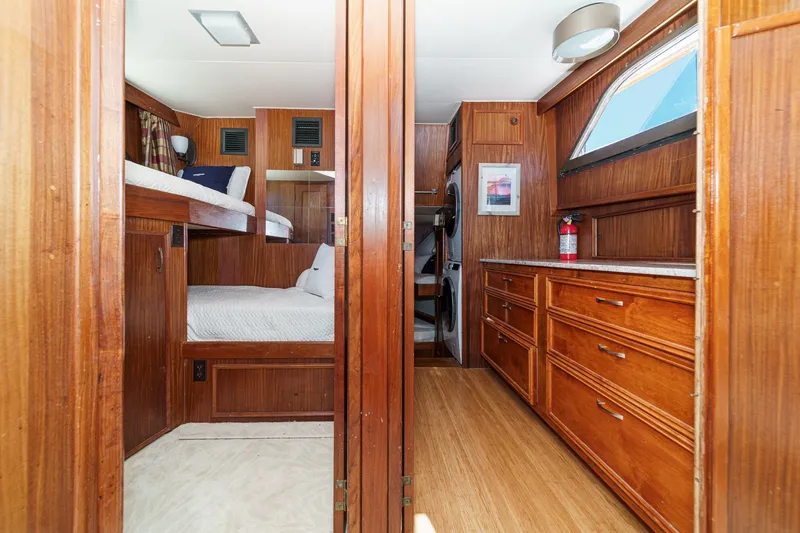 Slide: The Image of 1979 Hatteras 58 Motor Yacht interior with wooden cabinetry, bunk beds, and laundry area. - 47