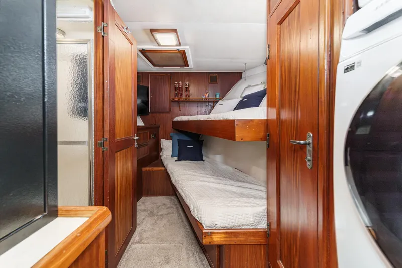 Slide: The Image of 1979 Hatteras 58 Motor Yacht interior with wooden cabinetry, bunk beds, and laundry area. - 50