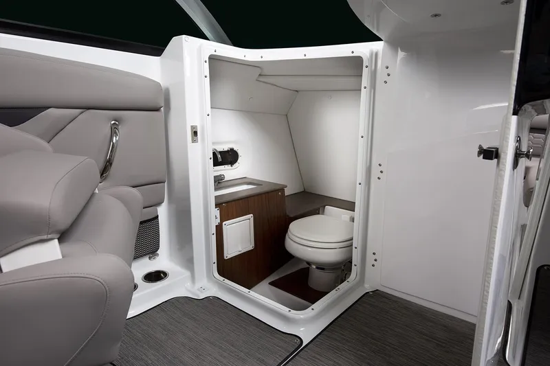 Slide: The Image of Manufacturer Provided Image: 2025 Four Winns HD8 OB boat interior with compact bathroom, featuring a toilet and sink. - 8