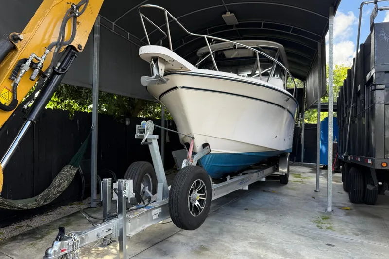 Slide: The Image of 2007 Grady-White Express 305 boat docked near construction equipment and a dog. - 33