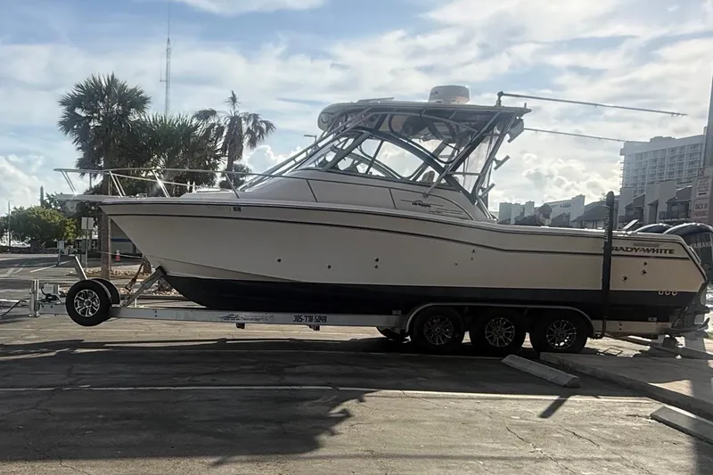 Slide: The Image of 2007 Grady-White Express 305 boat on trailer, parked outdoors under a partly cloudy sky. - 45
