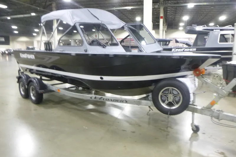 Slide: The Image of KingFisher 2025 Falcon boat on trailer in indoor showroom, 2026 model. - 13