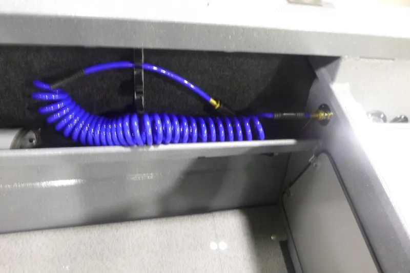 Slide: The Image of Coiled blue hose in KingFisher 2025 Falcon boat storage compartment, 2026 model. - 28