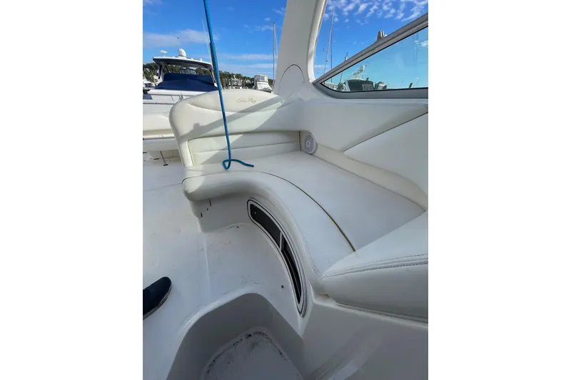 Slide: The Image of 2003 Sea Ray 280 Sundancer interior with white seating and blue sky background. - 10