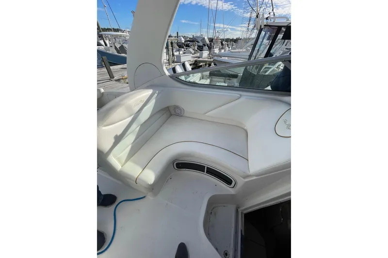 Slide: The Image of 2003 Sea Ray 280 Sundancer boat interior with white seating at marina. - 12