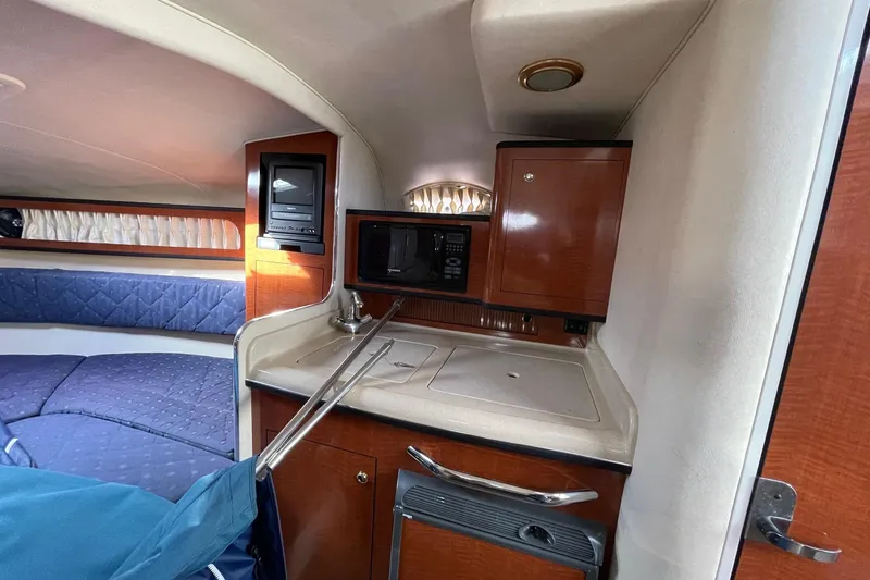 Slide: The Image of Interior of 2003 Sea Ray 280 Sundancer with kitchenette and seating area. - 17