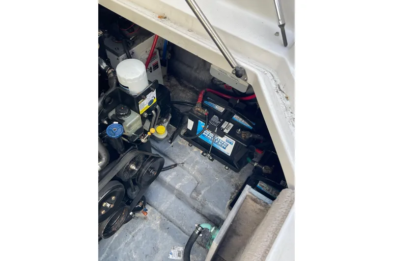 Slide: The Image of Engine compartment of 2003 Sea Ray 280 Sundancer with visible battery and components. - 25