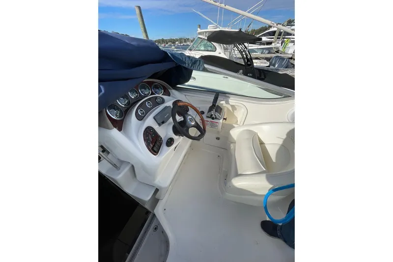 Slide: The Image of 2003 Sea Ray 280 Sundancer cockpit with steering wheel and instrument panel, docked at marina. - 6