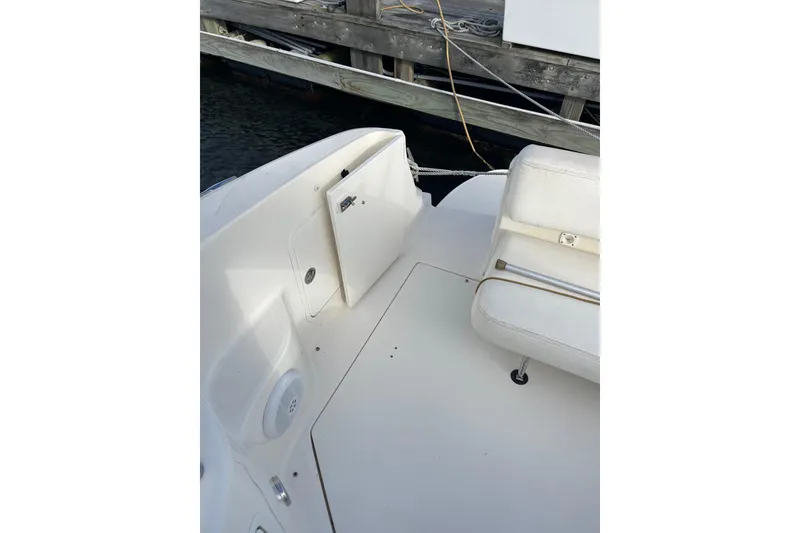Slide: The Image of 2003 Sea Ray 280 Sundancer boat interior with white seating and storage compartment. - 9