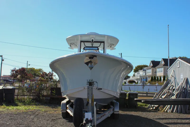 Slide: The Image of 2018 Sea Hunt Gamefish 30 boat on trailer, parked outdoors under clear blue sky. - 2