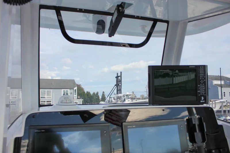 Slide: The Image of 2018 Sea Hunt Gamefish 30 cockpit with navigation screens and marina view. - 22