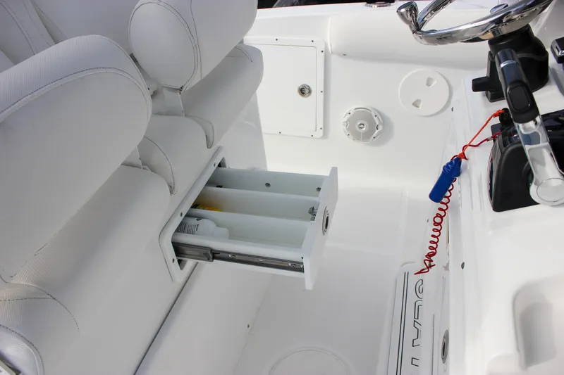Slide: The Image of 2018 Sea Hunt Gamefish 30 boat interior with storage drawer and steering wheel. - 25