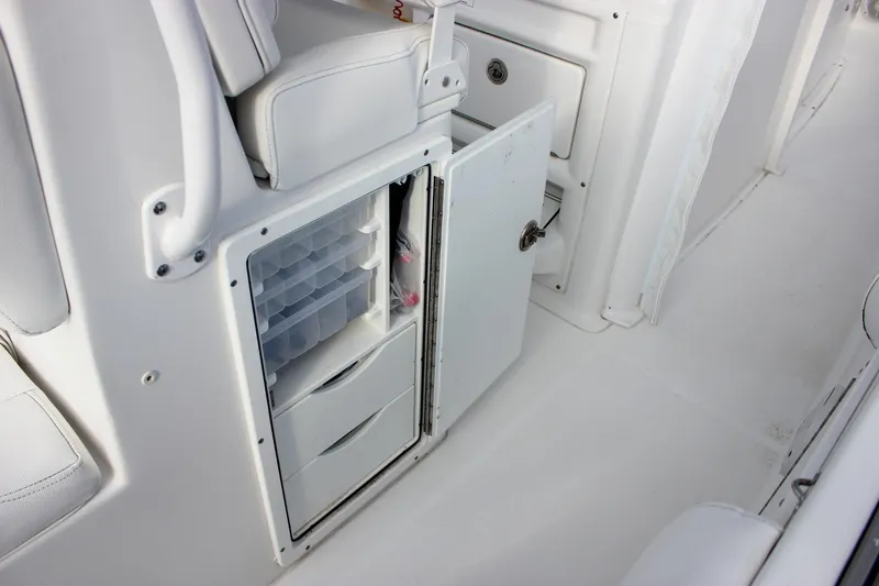 Slide: The Image of 2018 Sea Hunt Gamefish 30 boat storage compartment with open door and organized trays. - 33