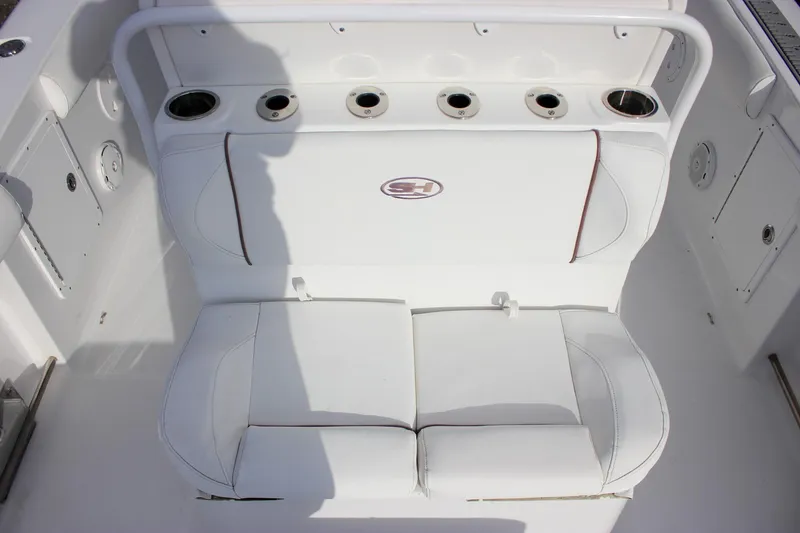 Slide: The Image of 2018 Sea Hunt Gamefish 30 boat seating area with cup holders and white upholstery. - 45