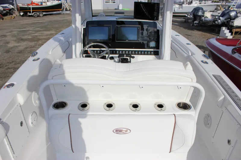 Slide: The Image of 2018 Sea Hunt Gamefish 30 boat interior with helm, seating, and cup holders. - 46