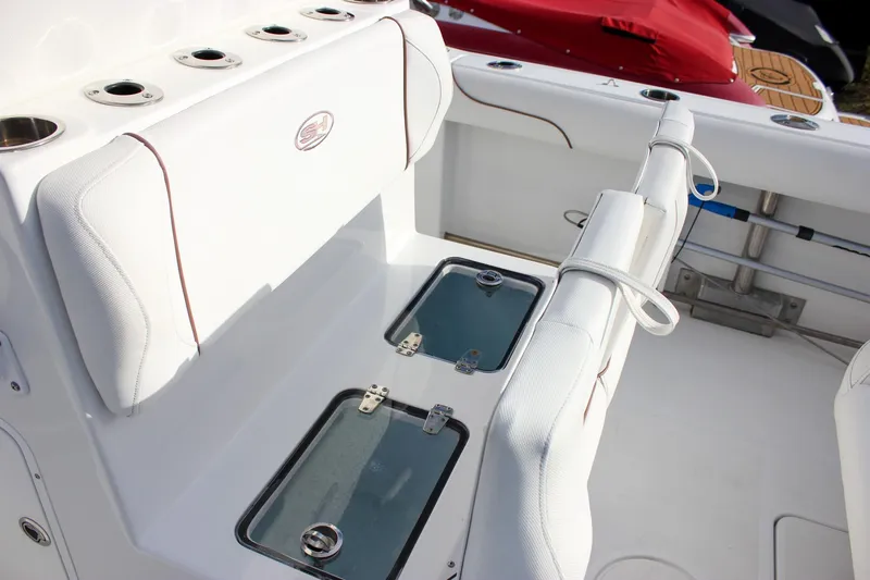 Slide: The Image of 2018 Sea Hunt Gamefish 30 boat interior with white seating and storage compartments. - 47