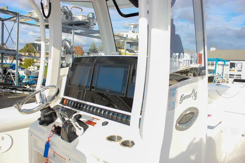 Slide: The Image of 2018 Sea Hunt Gamefish 30 boat dashboard with steering wheel and navigation screens. - 50