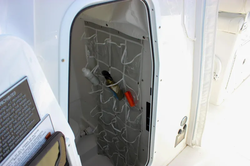 Slide: The Image of 2018 Sea Hunt Gamefish 30 storage compartment with organized pockets and cleaning supplies. - 55