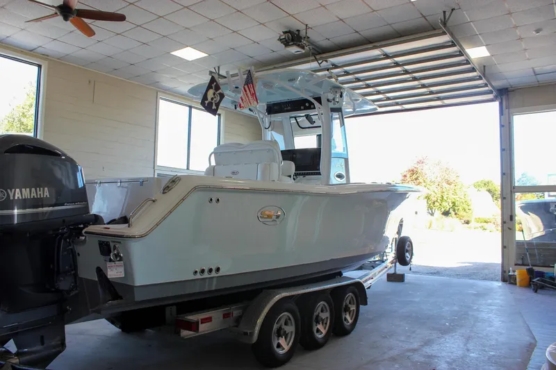 Slide: The Image of 2018 Sea Hunt Gamefish 30 boat on trailer in garage with Yamaha engine. - 67