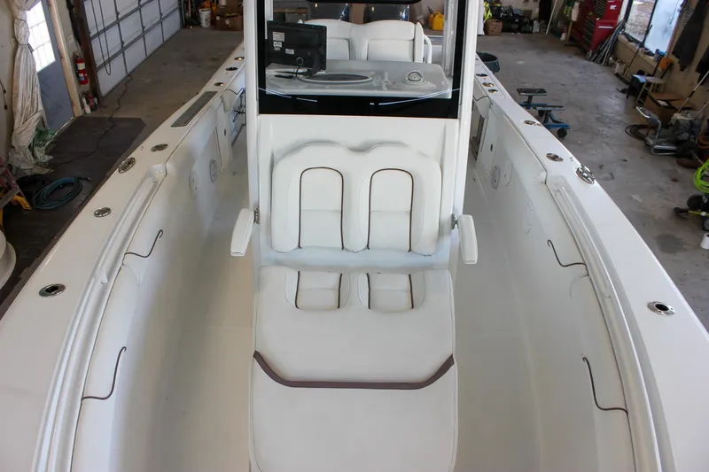 Slide: The Image of 2018 Sea Hunt Gamefish 30 boat interior with white seating in a garage setting. - 71