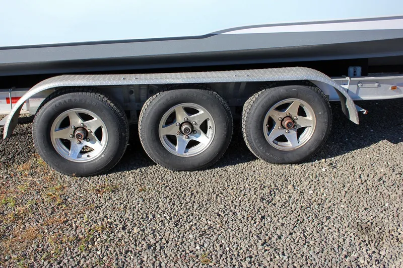 Slide: The Image of Triple-axle trailer for 2018 Sea Hunt Gamefish 30 on gravel surface. - 80