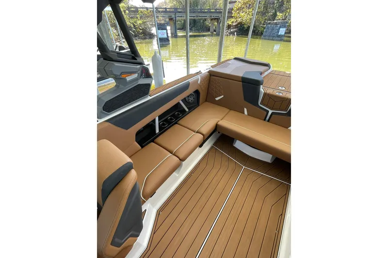 Slide: The Image of 2024 Nautique Super Air Nautique GS22 interior with brown seating and sleek design. - 15