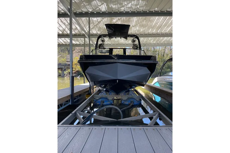 Slide: The Image of 2024 Nautique Super Air Nautique GS22 boat docked in a covered marina. - 2