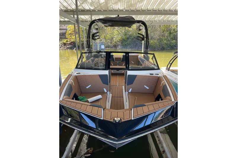 Slide: The Image of 2024 Nautique Super Air Nautique GS22 boat with sleek interior design, docked under a canopy. - 3