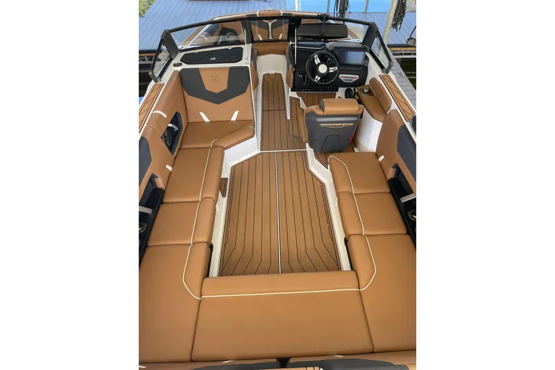 Slide: The Image of 2024 Nautique Super Air Nautique GS22 interior with tan seating and sleek dashboard design. - 5