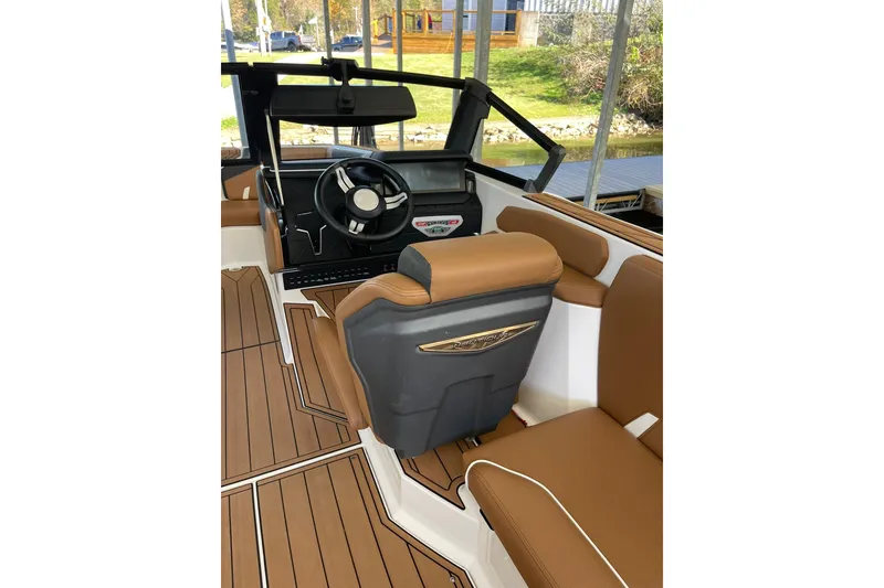 Slide: The Image of 2024 Nautique Super Air Nautique GS22 interior with brown seating and modern dashboard. - 6