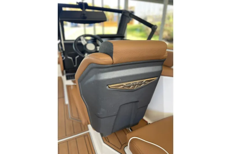 Slide: The Image of 2024 Nautique Super Air Nautique GS22 interior with brown seating and steering wheel. - 7