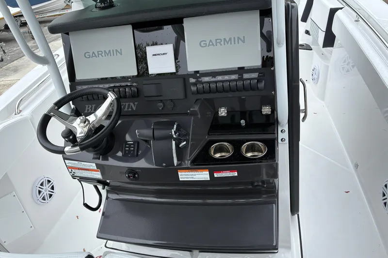 Slide: The Image of 2026 Blackfin 272 CC boat dashboard with Garmin displays and steering wheel. - 15