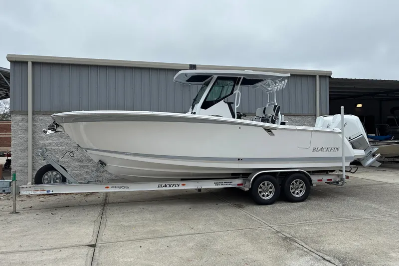 Slide: The Image of 2026 Blackfin 272 CC boat on trailer, parked outside a storage facility. - 25