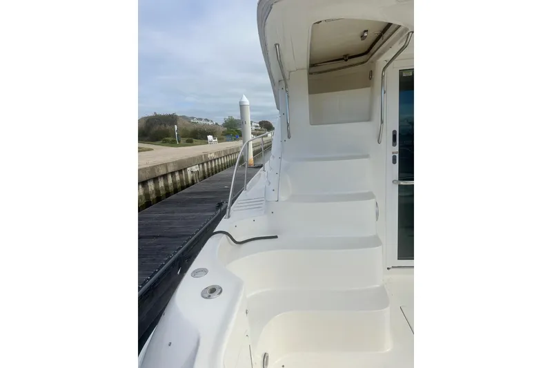 Slide: The Image of 2001 Sea Ray 400 Sedan Bridge yacht with white exterior and dockside view. - 10