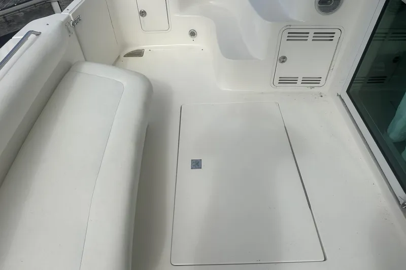 Slide: The Image of 2001 Sea Ray 400 Sedan Bridge boat interior with white seating and storage compartments. - 11