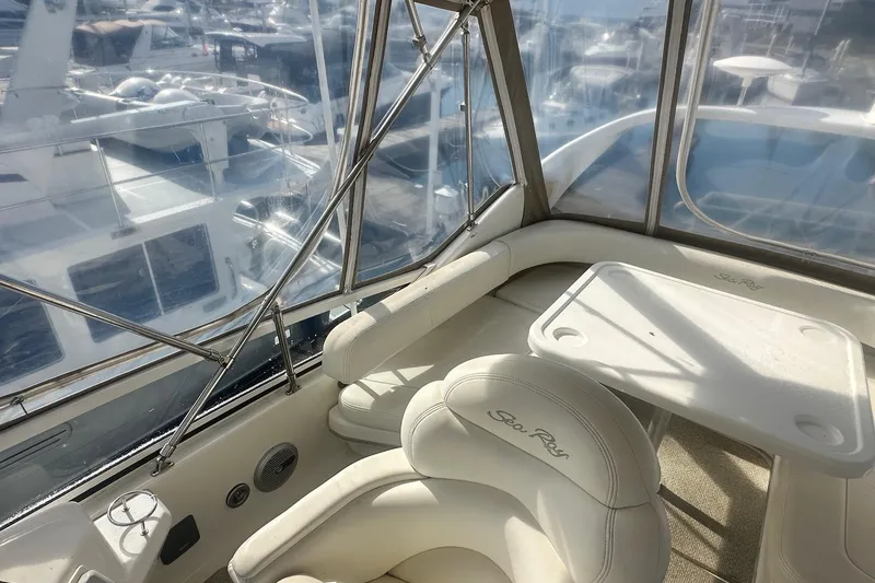 Slide: The Image of 2001 Sea Ray 400 Sedan Bridge interior with white seating and table, marina view. - 15