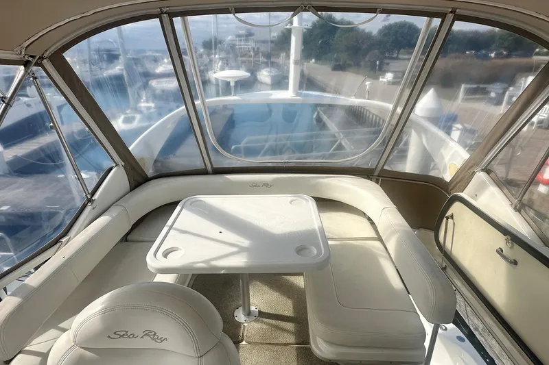 Slide: The Image of 2001 Sea Ray 400 Sedan Bridge interior with seating and table, overlooking marina. - 16