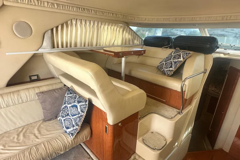 Slide: The Image of Interior of 2001 Sea Ray 400 Sedan Bridge with beige seating and decorative pillows. - 22