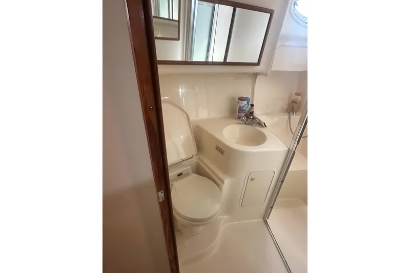 Slide: The Image of Bathroom interior of 2001 Sea Ray 400 Sedan Bridge yacht, featuring sink and toilet. - 25