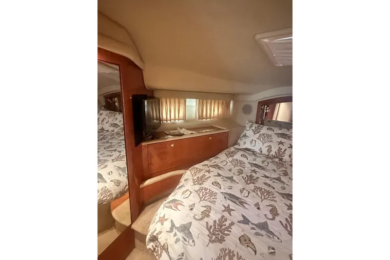 Slide: The Image of Cozy bedroom interior of 2001 Sea Ray 400 Sedan Bridge yacht with nautical-themed bedding. - 28