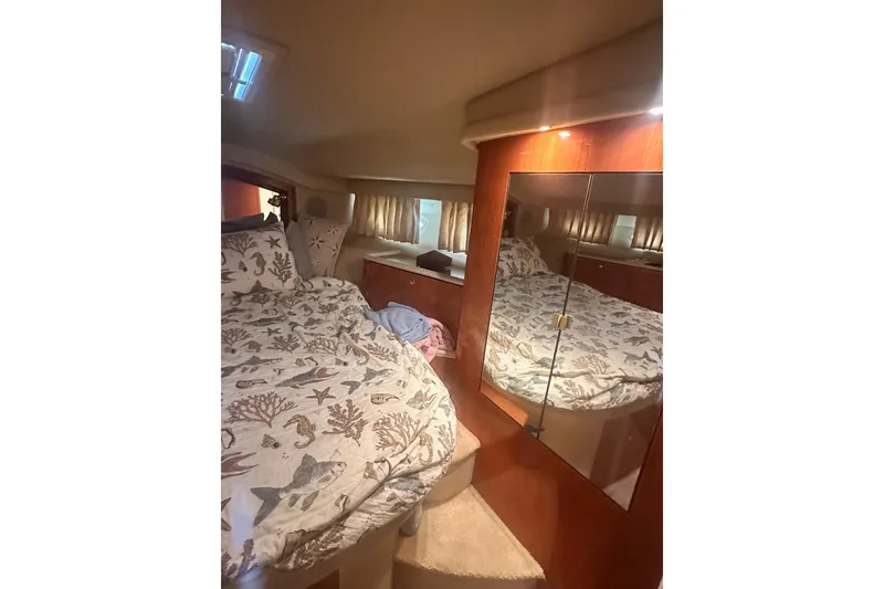 Slide: The Image of Interior cabin of 2001 Sea Ray 400 Sedan Bridge with nautical-themed bedding. - 29