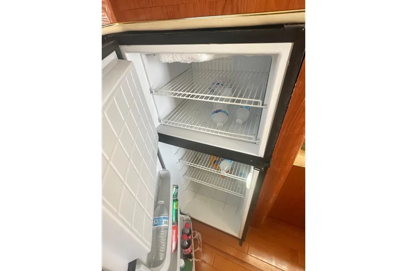 Slide: The Image of Fridge interior on 2001 Sea Ray 400 Sedan Bridge yacht, partially stocked with beverages. - 33