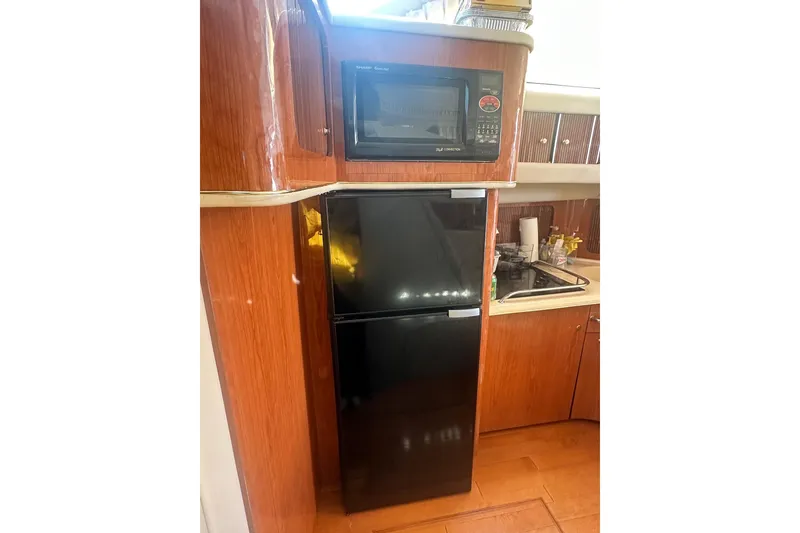 Slide: The Image of Kitchen area of 2001 Sea Ray 400 Sedan Bridge with microwave and fridge. - 34