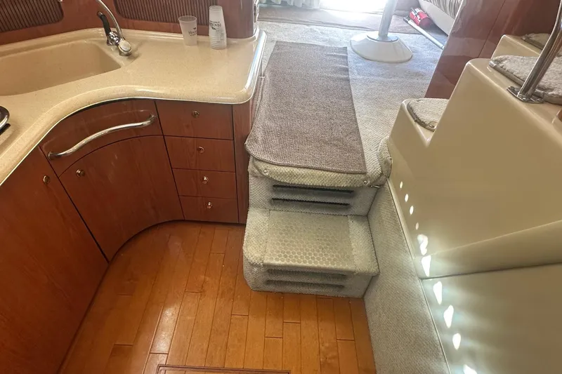 Slide: The Image of Interior of 2001 Sea Ray 400 Sedan Bridge with wooden flooring and carpeted stairs. - 38