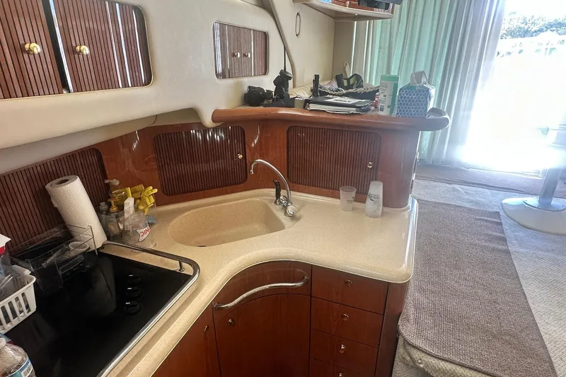 Slide: The Image of 2001 Sea Ray 400 Sedan Bridge kitchen with sink, stove, and wooden cabinets. - 39