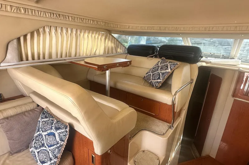 Slide: The Image of Interior of 2001 Sea Ray 400 Sedan Bridge with beige seating and decorative pillows. - 42