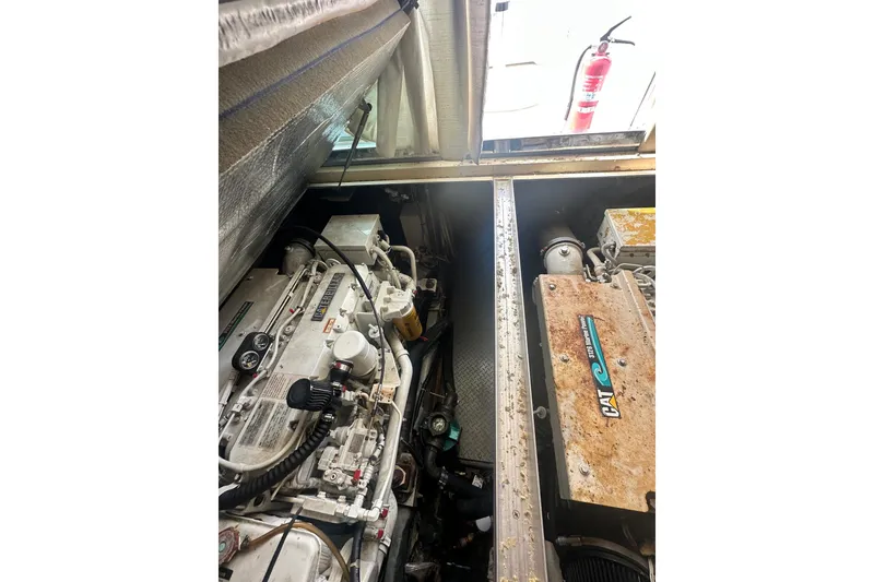 Slide: The Image of Engine room of a 2001 Sea Ray 400 Sedan Bridge with visible machinery and fire extinguisher. - 49