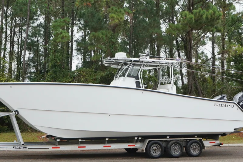 Slide: The Image of Freeman 33 boat on trailer, surrounded by trees, 2013 model. - 12
