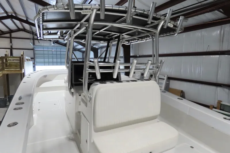 Slide: The Image of 2013 Freeman 33 boat interior with seating and rod holders in a warehouse. - 17