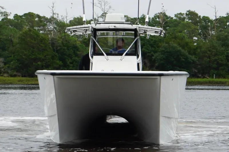 Slide: The Image of Freeman 33 boat from 2013 on water, front view with lush greenery background. - 9